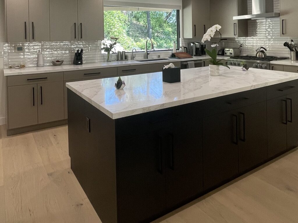 Two-tone kitchen with a dark island and white oak perimeter cabinets