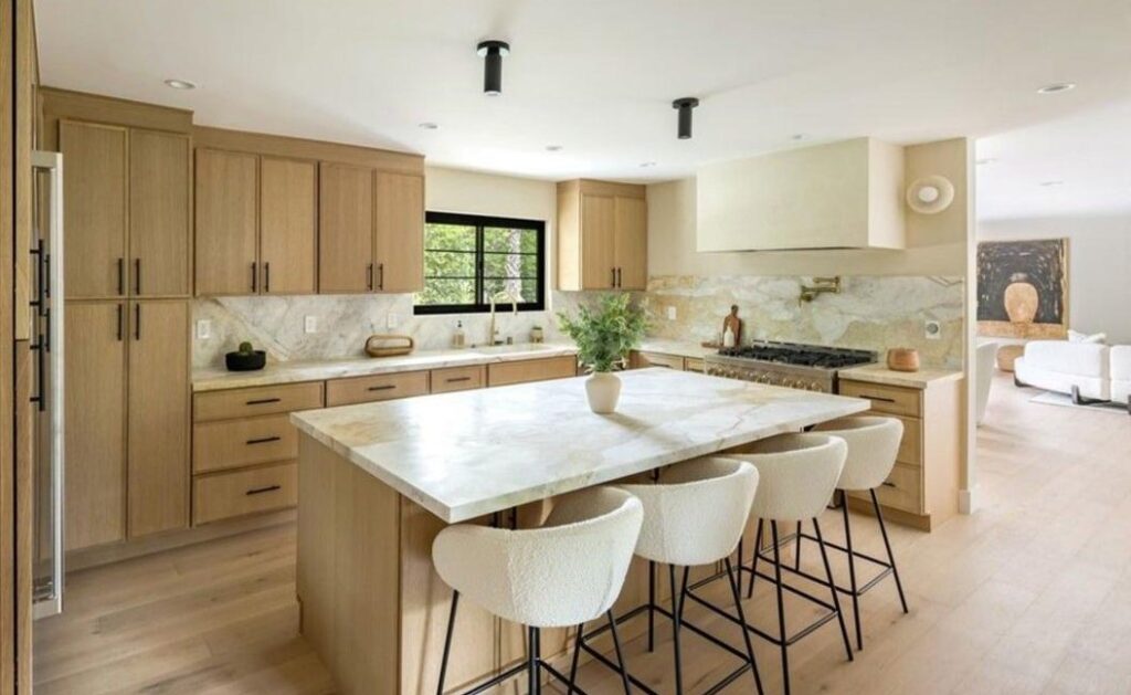Kitchen with white oak cabinets, quartzite countertops and black-framed windows